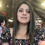 la imagen puede contener a una mujer de cabello castaño sentada y sonriendo levemente 